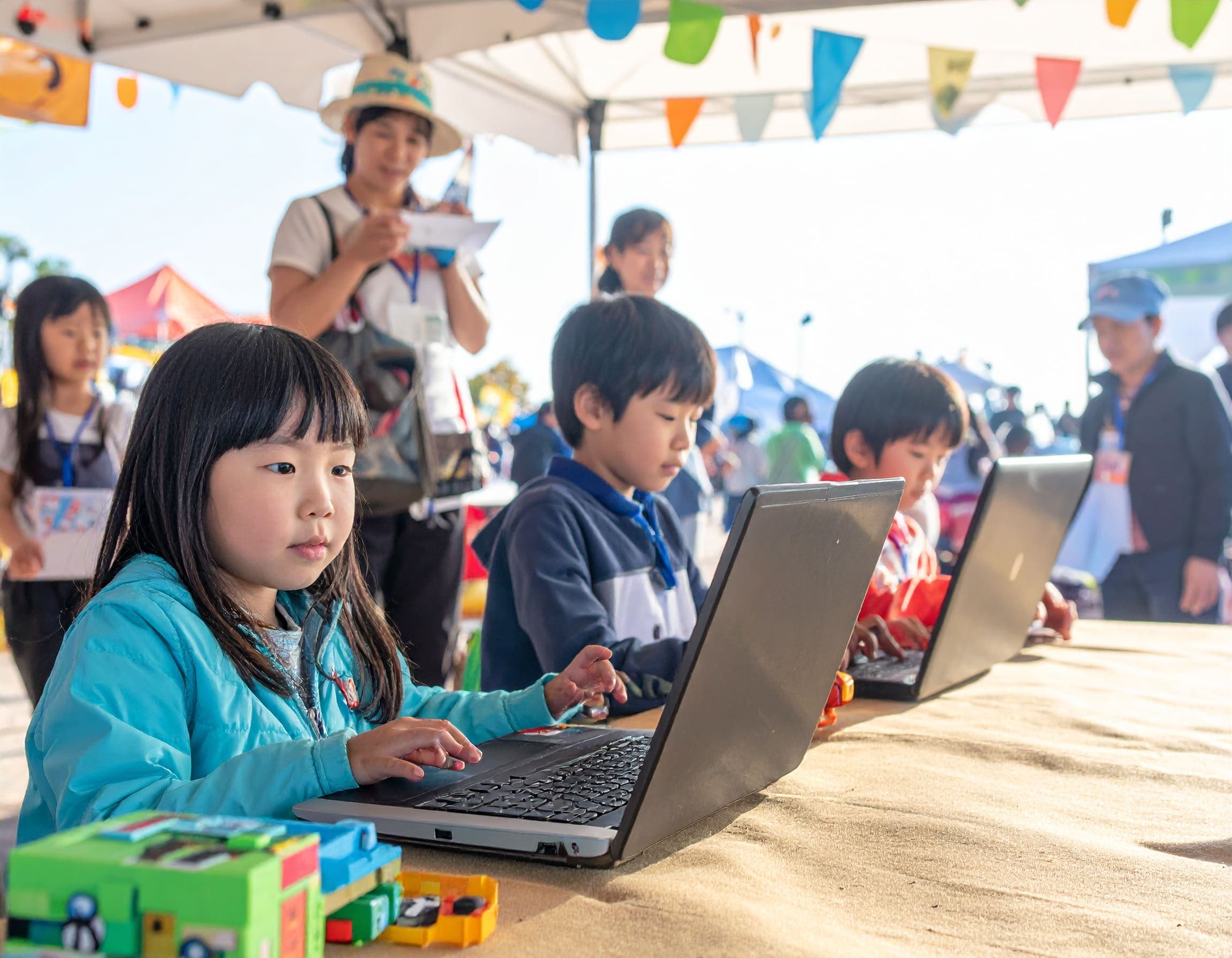 イベントブースでノートパソコンに向かい、マインクラフトに熱中する子どもたち